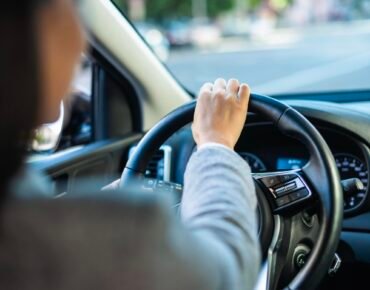 A driving school student behind the wheel of a car during a practical driving lesson.