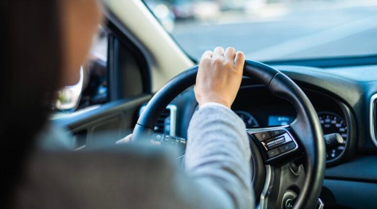 A driving school student behind the wheel of a car during a practical driving lesson.